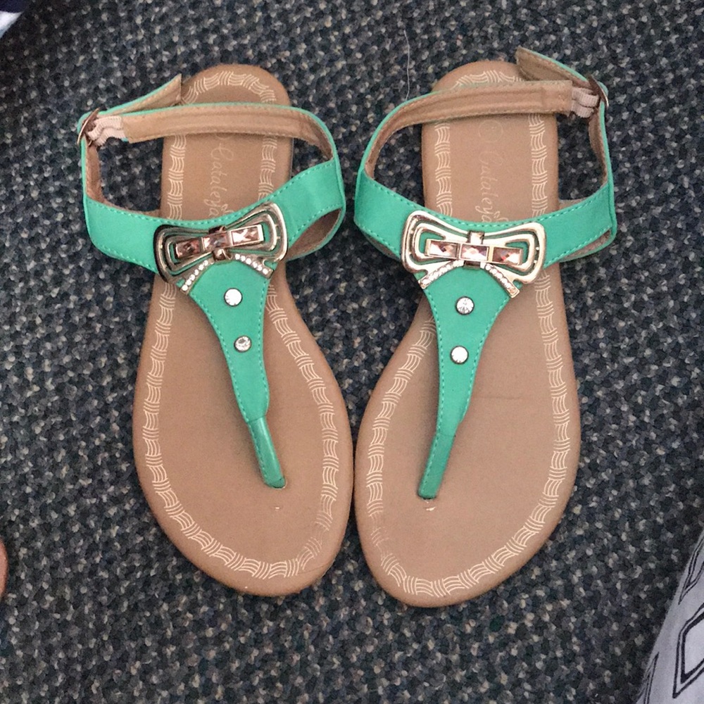 Green sandals with gold bow embellishment